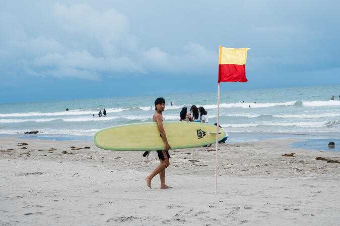 A surfer taking on the waves at Bagasbas Beach in Daet, Camarines Sur.